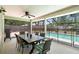 Relaxing screened-in patio featuring a dining table, fan, and pool view at 25 Pine Glen Dr, Debary, FL 32713