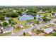 A picturesque aerial view of a home near a tranquil lake, surrounded by lush greenery and neighborhood streets at 2517 Oak Hollow Dr, Kissimmee, FL 34744