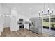 Bright kitchen featuring stainless steel appliances, white cabinetry, and a stylish chandelier at 2517 Oak Hollow Dr, Kissimmee, FL 34744