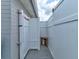 Outdoor shower with wooden bench surrounded by white fencing and siding for privacy at 26 Ocean Shore Dr, Ormond Beach, FL 32176