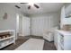 Bright Bedroom with white furniture, including a crib, dresser, and glider chair, and soft carpet at 2842 English Dr, Deltona, FL 32738