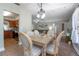 Elegant dining room with a rustic light fixture, tile flooring, and views into the kitchen and living areas at 2842 English Dr, Deltona, FL 32738