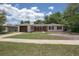 Charming single-story home with a brick and white exterior, a well-manicured lawn, and a driveway leading to an attached garage at 2842 English Dr, Deltona, FL 32738