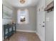 Inviting foyer with neutral walls, a console table, tile flooring, and a view of the front door and window at 2842 English Dr, Deltona, FL 32738