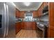 Modern kitchen with wood cabinetry, stainless steel appliances, granite countertops, and hardwood floors at 2842 English Dr, Deltona, FL 32738