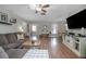 Spacious living room with hardwood floors, a comfortable sofa, a ceiling fan, and large TV at 2842 English Dr, Deltona, FL 32738