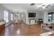 Spacious living room with hardwood floors, a comfortable sofa, a ceiling fan, and large TV at 2842 English Dr, Deltona, FL 32738