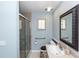 Cozy bathroom with blue walls, a shower with a glass door, and a framed mirror above the vanity at 2953 Sled Rd, Christmas, FL 32709