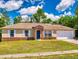 Charming single-story home with a brick facade, an attached two-car garage and well-manicured front yard at 2978 Greynolds St, Deltona, FL 32738