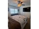 Comfortable bedroom with ceiling fan, TV, and a large window at 3003 S Atlantic Ave # 17A1, Daytona Beach Shores, FL 32118