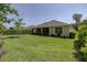 Beautifully landscaped backyard with lush green lawn, mature trees, and screened-in lanai for outdoor enjoyment at 3026 Adrian Dr, Ormond Beach, FL 32174