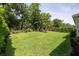 Expansive green backyard offers plenty of space for recreation and relaxation, surrounded by mature trees at 3026 Adrian Dr, Ormond Beach, FL 32174