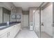 Modern bathroom featuring double sinks, white cabinets, and a glass-enclosed shower with white tile at 3026 Adrian Dr, Ormond Beach, FL 32174