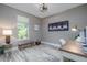 This is a cozy bedroom or office space featuring light grey walls and wood-look flooring, creating a serene environment at 3026 Adrian Dr, Ormond Beach, FL 32174