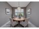 Cozy dining room with a round wooden table, upholstered chairs, window with natural light, and decorative wall art at 3026 Adrian Dr, Ormond Beach, FL 32174