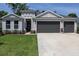 Charming home exterior featuring a two-car garage, decorative stone accents, and a well-maintained front yard at 3026 Adrian Dr, Ormond Beach, FL 32174