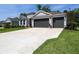 Beautiful two-story home with a three-car garage, well-manicured lawn, and lush landscaping at 3026 Adrian Dr, Ormond Beach, FL 32174