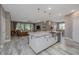 Bright kitchen island with white cabinets, granite countertops, and open view of the living area at 3026 Adrian Dr, Ormond Beach, FL 32174