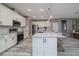 Bright kitchen with white cabinets, stainless steel appliances, granite countertops, and a large center island with barstool seating at 3026 Adrian Dr, Ormond Beach, FL 32174