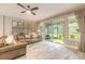 Cozy living room with a comfortable leather sofa, glass coffee table, decorative maps, and access to the outdoor patio at 3026 Adrian Dr, Ormond Beach, FL 32174