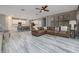Open-concept living room featuring a leather couch, hardwood floors, and kitchen with stainless steel appliances at 3026 Adrian Dr, Ormond Beach, FL 32174