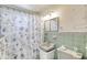 Classic bathroom with a seashell-themed shower curtain, a vanity, and tiled walls at 31 River Shore Dr, Ormond Beach, FL 32176