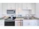 Well-equipped kitchen featuring modern appliances, sleek countertops, and stylish white cabinetry at 31 River Shore Dr, Ormond Beach, FL 32176