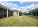 Green backyard with a black fence, grass and view of the screened in patio at 319 Bellingrath Ter, Deland, FL 32724