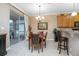 A cozy dining room with a chandelier, a painting, and an outdoor patio with a grill beyond the sliding glass doors at 319 Bellingrath Ter, Deland, FL 32724