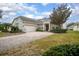 Charming home with a winding brick driveway, mature landscaping, and attached garage at 319 Bellingrath Ter, Deland, FL 32724