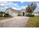 Charming home with a winding brick driveway, mature landscaping, and attached garage at 319 Bellingrath Ter, Deland, FL 32724