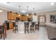 Eat-in kitchen bar with granite counters, pendant lights, wooden cabinets, and access to the home's entry and main living area at 319 Bellingrath Ter, Deland, FL 32724