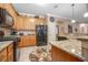 Open kitchen featuring granite countertops, wood cabinets, and stainless appliances at 319 Bellingrath Ter, Deland, FL 32724