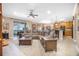 An open concept living room with a sectional sofa, ceiling fan, and easy access to the kitchen, dining, and patio at 319 Bellingrath Ter, Deland, FL 32724