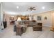 Open-concept living room featuring a comfortable sectional sofa, ceiling fan, tile floors and views into the dining and kitchen areas at 319 Bellingrath Ter, Deland, FL 32724