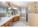 Bathroom with double sinks, a soaking tub, walk-in shower, decorative mirrors, and cabinet storage space at 319 Bellingrath Ter, Deland, FL 32724