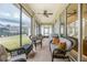 Relaxing screened patio with comfortable seating, ceiling fan, and brick flooring overlooking the backyard at 319 Bellingrath Ter, Deland, FL 32724