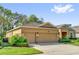 Side view of a tan home with a three car garage showing the driveway, lawn, and some landscaping at 320 W Victoria Trails Blvd, Deland, FL 32724
