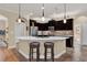 Stylish kitchen features dark wood cabinetry, stainless steel appliances, and a large center island with seating at 320 W Victoria Trails Blvd, Deland, FL 32724