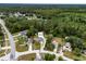 A quiet suburban street leads to a well-kept home with a detached three-car garage surrounded by lush trees at 3210 Whitehorse Ct, Deltona, FL 32738