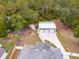 Aerial view of property with brick home, wooded area and large detached garage at 3210 Whitehorse Ct, Deltona, FL 32738