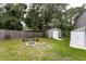 Well-maintained backyard featuring a fire pit, bench, and storage shed, perfect for outdoor relaxation at 3210 Whitehorse Ct, Deltona, FL 32738