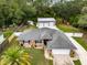 An exterior elevation showcases this well-kept home and a detached three-car garage with mature landscaping at 3210 Whitehorse Ct, Deltona, FL 32738