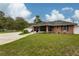 View of the side of the brick home showing the screened in porch and grassy lawn at 3210 Whitehorse Ct, Deltona, FL 32738