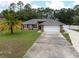 Single-story brick home featuring a well-manicured lawn and mature landscaping at 3210 Whitehorse Ct, Deltona, FL 32738