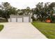 Spacious three-car garage with a paved driveway and well-manicured lawn; perfect for car enthusiasts at 3210 Whitehorse Ct, Deltona, FL 32738