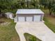 Aerial view of the large detached garage with three bays and long concrete driveway at 3210 Whitehorse Ct, Deltona, FL 32738