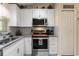 Well-equipped kitchen with stainless steel appliances, granite countertops, and white cabinets at 3210 Whitehorse Ct, Deltona, FL 32738
