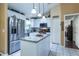 Modern kitchen featuring granite counters, stainless steel appliances, kitchen island, and white cabinetry at 3210 Whitehorse Ct, Deltona, FL 32738