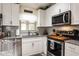 Modern kitchen featuring stainless steel appliances, granite countertops, and white cabinets at 3210 Whitehorse Ct, Deltona, FL 32738